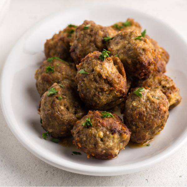 Italian Meatballs stacked on a plate for serving.