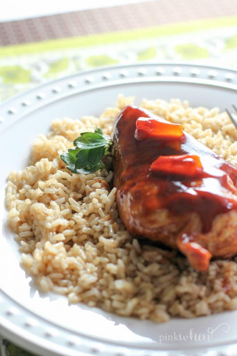Hawaiian Chicken served over a bed of rice on a white plate. 