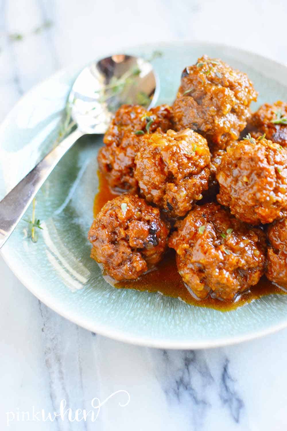 BBQ meatballs on a plate with a spoon. 