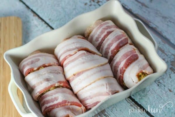 bacon wrapped chicken in white baking dish ready to be cooked