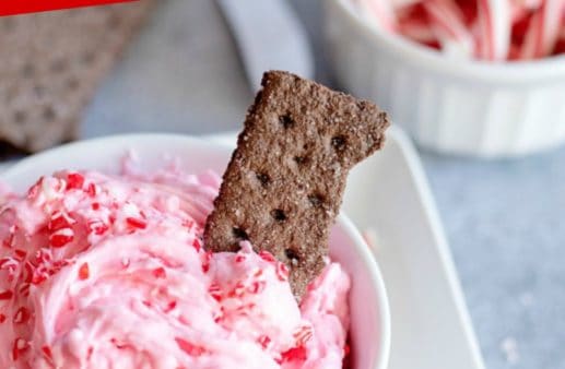 Cream cheese candy cane dip in white bowl with graham cracker.