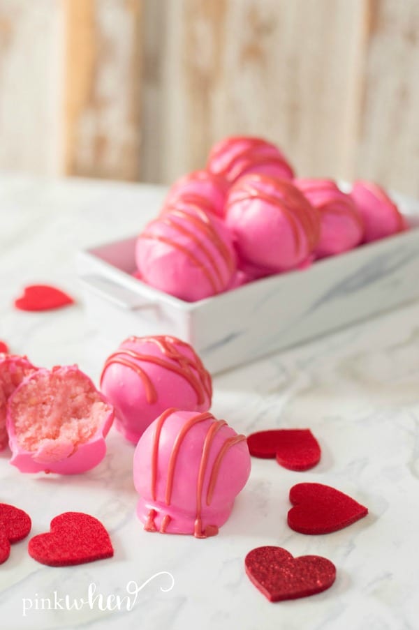 Pink cake balls recipe in tray and on a table. 