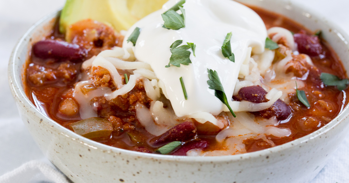 the best chili recipe topped with sour cream and green onion.