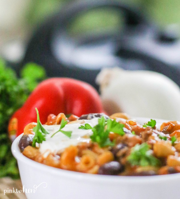 Chili Mac made in the pressure cooker in a white bowl with toppings. 