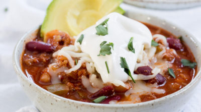 chili topped with sour cream and avocado