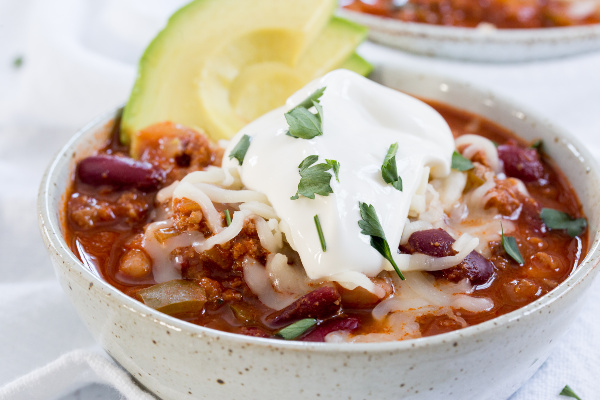 Chili topped with sour cream, avocado, and fresh parsley. 