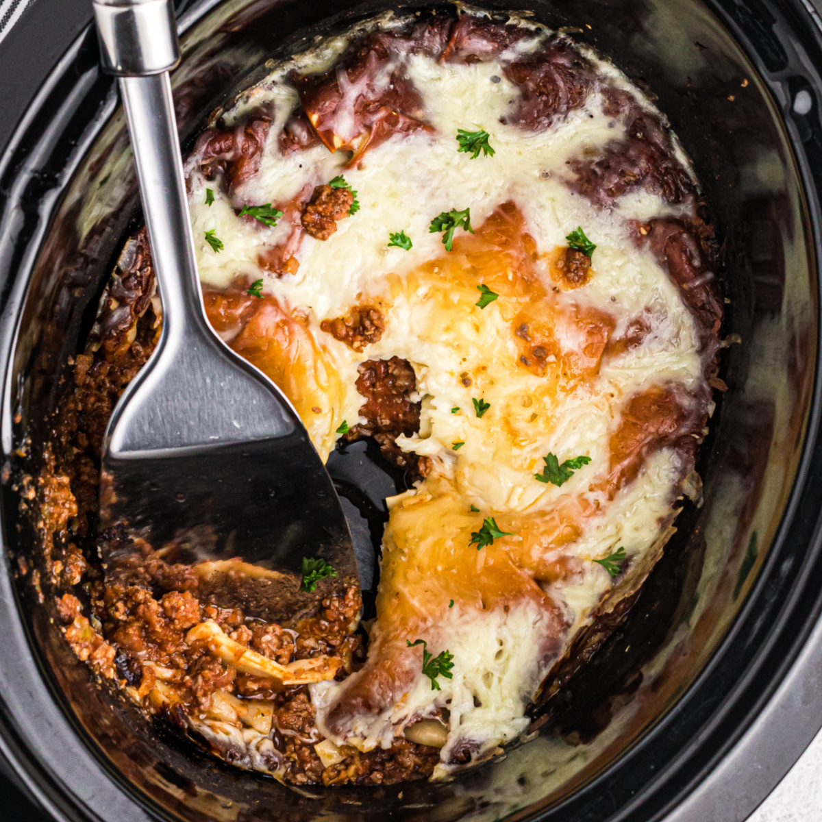 Lasagna in a crockpot ready to serve.