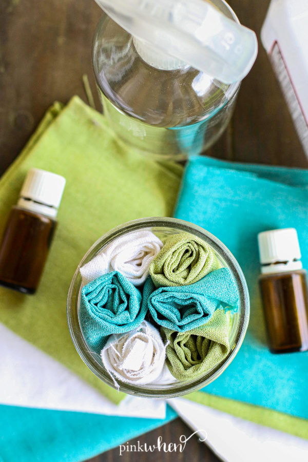 Homemade Disinfecting Wipes in a glass jar on a table. 