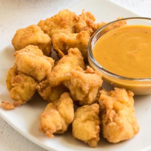 Copycat Chick Fil A Chicken Nuggets on a plate with homemade sauce.