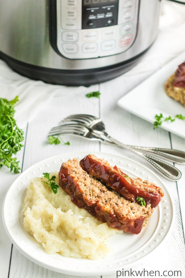 Meatloaf made in the Instant Pot on a plate with mashed potatoes. 