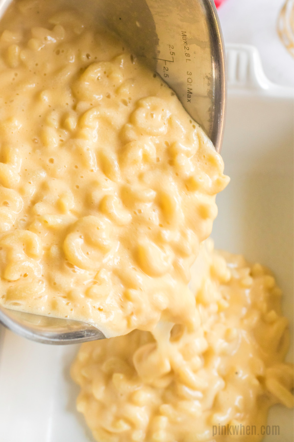 pouring macaroni and cheese into casserole dish.