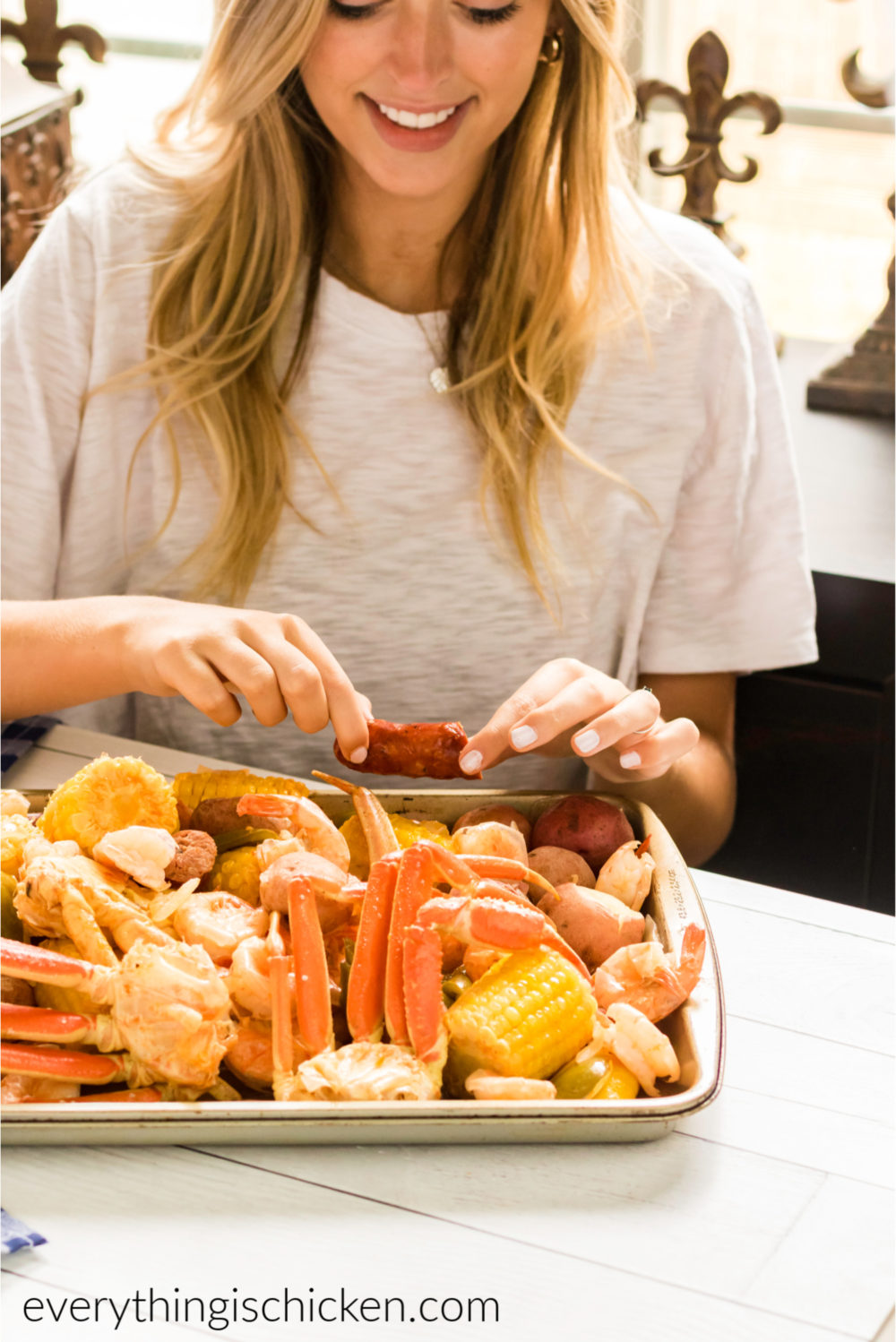 Girl eating a tray with a cajun seafood boil. 