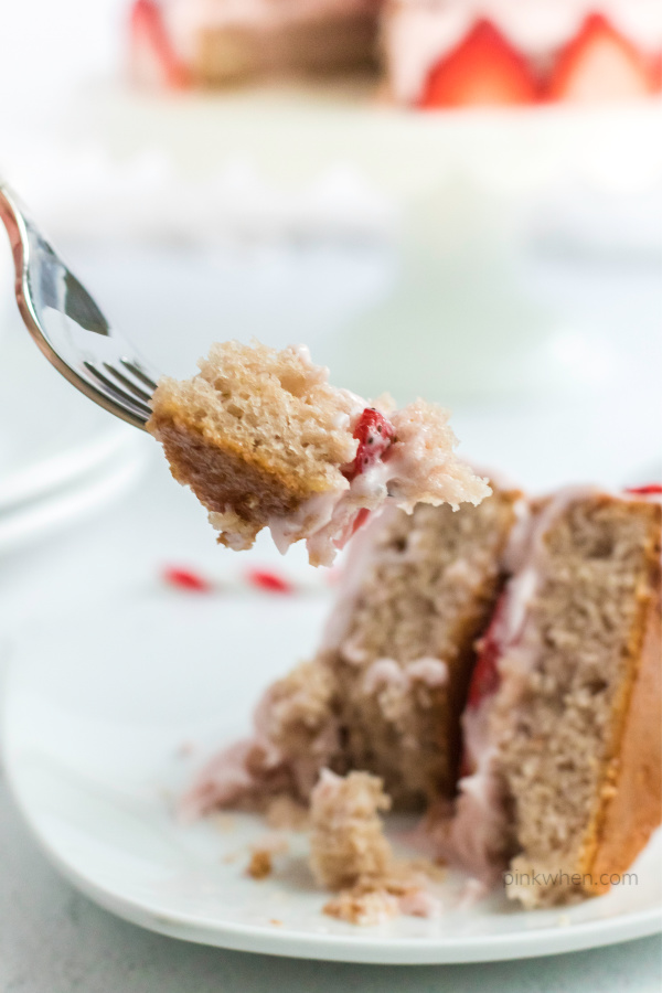 Strawberry Cake sliced and a bite on a fork being served.