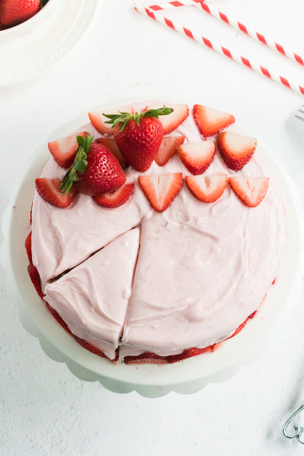 Strawberry Cake with Strawberry Cream Cheese frosting with a slice cut into the cake.