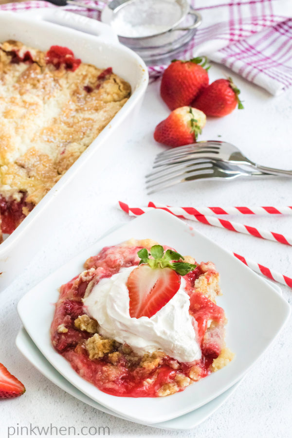 Strawberry Dump Cake with a scoop of whipped cream on top. 