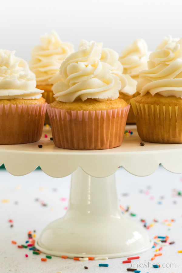 cupcakes with buttercream frosting on a cake stand.