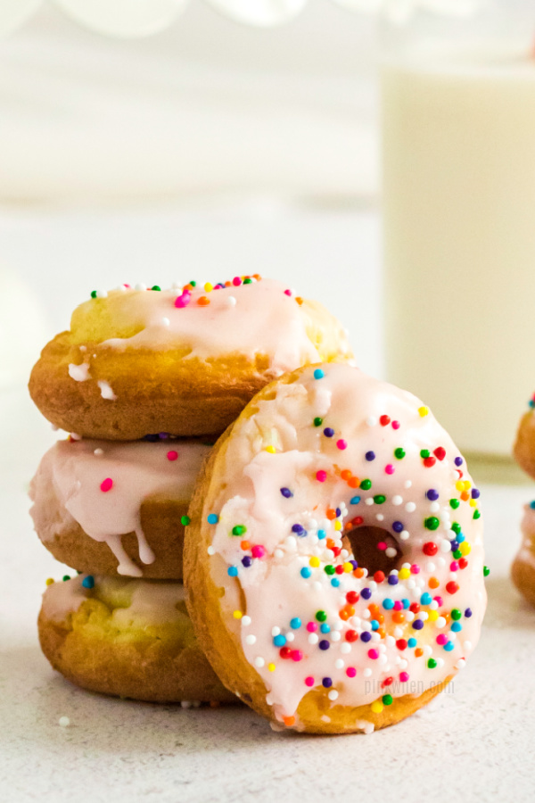 Cake mix donuts covered with frosting and sprinkles and stacked.