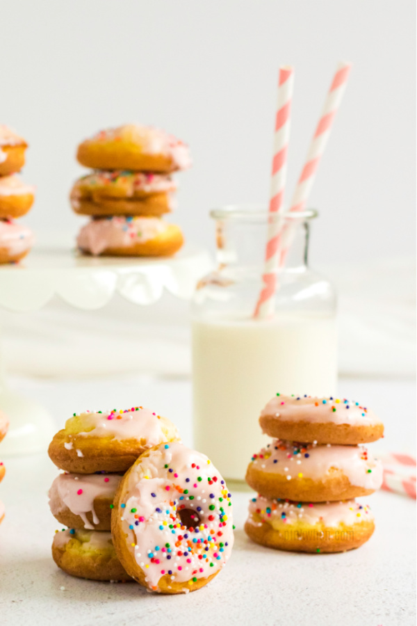 Cake Mix Donuts stacked and covered with icing and sprinkles.
