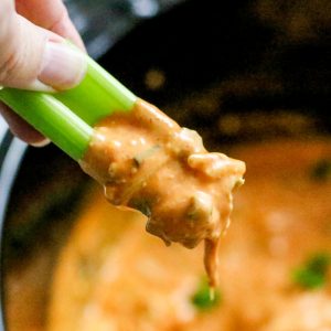 Chicken dip being scooped with celery.