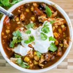 Chicken Chili garnished with sour cream and onion tops.