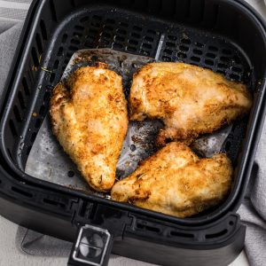 Air Fryer Chicken breast fully cooked in a basket.