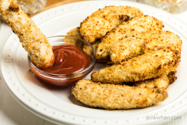 Air Fryer Chicken Strips with one dipped into ketchup.