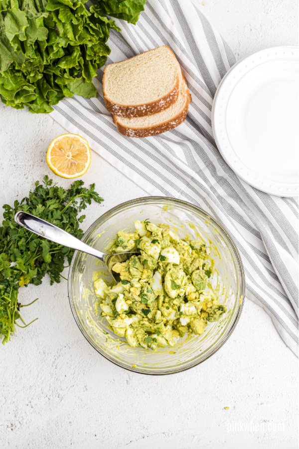 Avocado egg salad ingredients mixed in a bowl.