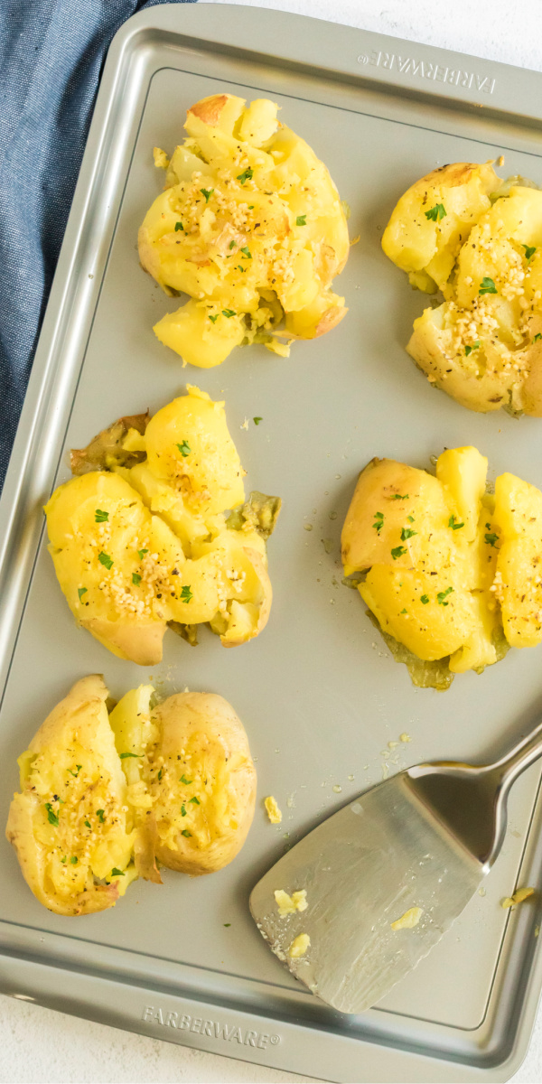 Family Approved! Crispy Garlic Smashed Potatoes are made with Yukon gold potatoes, minced garlic, and freshly grated parmesan cheese. Add butter, oil, and garnish with fresh parsley to make them complete. Perfect for a side, or all by itself!