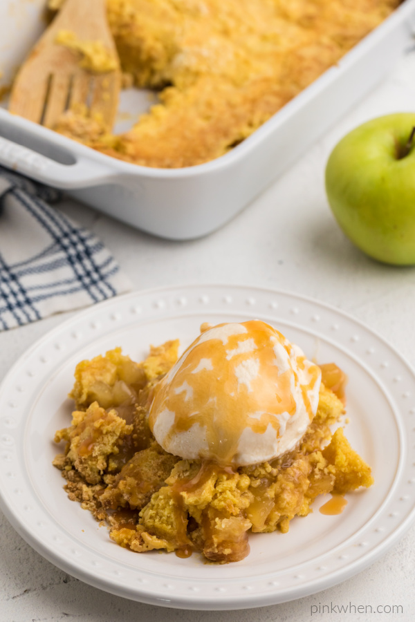 Apple dump cake with ice cream and caramel drizzled on top.