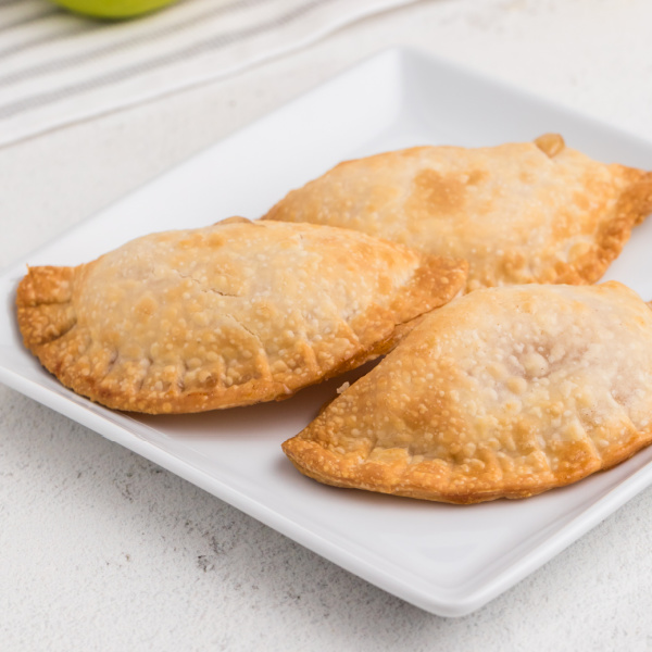 Apple hand pies on a white plate.