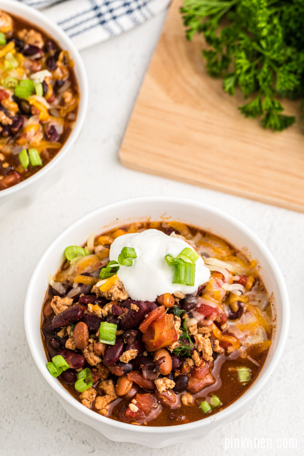 Slow Cooker Turkey Chili with toppings in a white bowl ready to eat. 