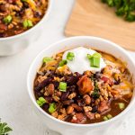 Slow Cooker Turkey Chili with toppings in a white bowl.
