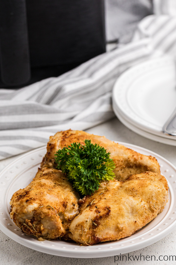 Chicken breasts made in the Air Fryer on a white plate and ready to serve.