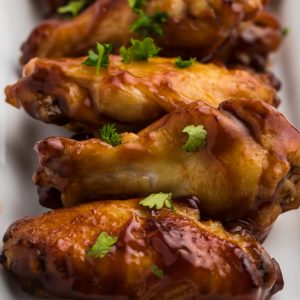 Air Fried BBQ Chicken Wings on a white serving dish sprinkled with fresh parsley.