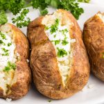 Baked Potatoes topped with sour cream and fresh parsley.