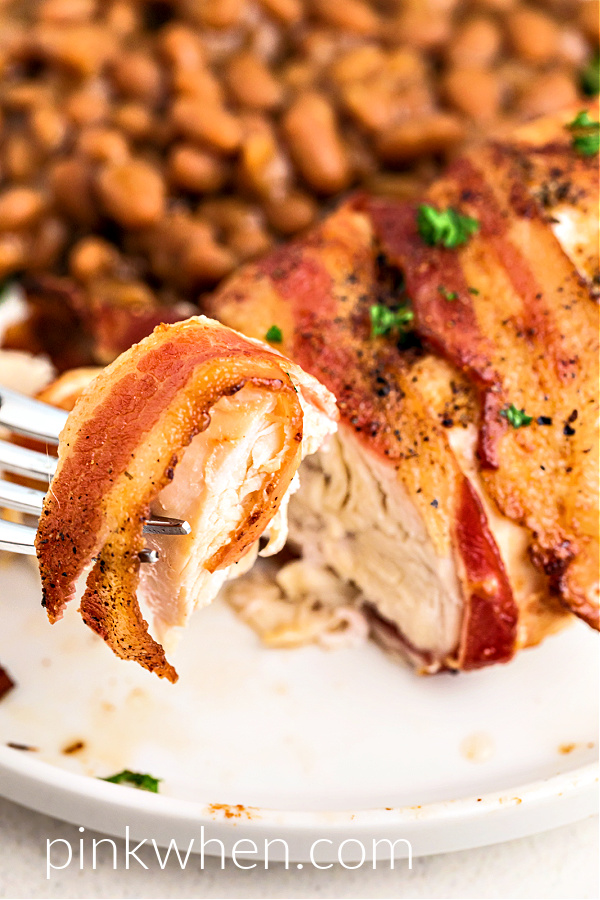 Close up photo of a bite of air fryer bacon wrapped chicken ready to eat. 