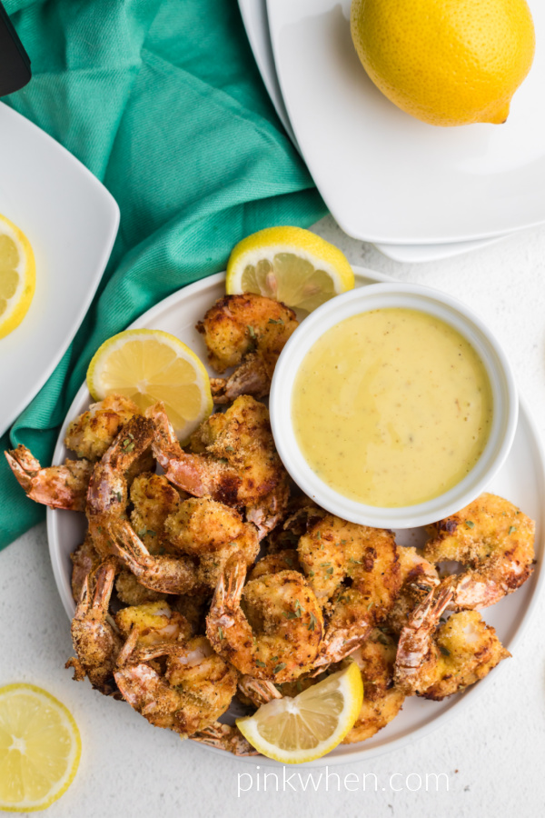 Air Fried Keto Fried Shrimp on a white plate with lemon slices and dipping sauce. 
