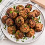 Air Fryer Turkey meatballs in a white plate garnished with fresh parsley.