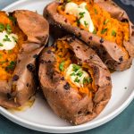 baked sweet potatoes made in the air fryer and topped with butter and fresh parsley.