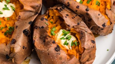 baked sweet potatoes made in the air fryer and topped with butter and fresh parsley.