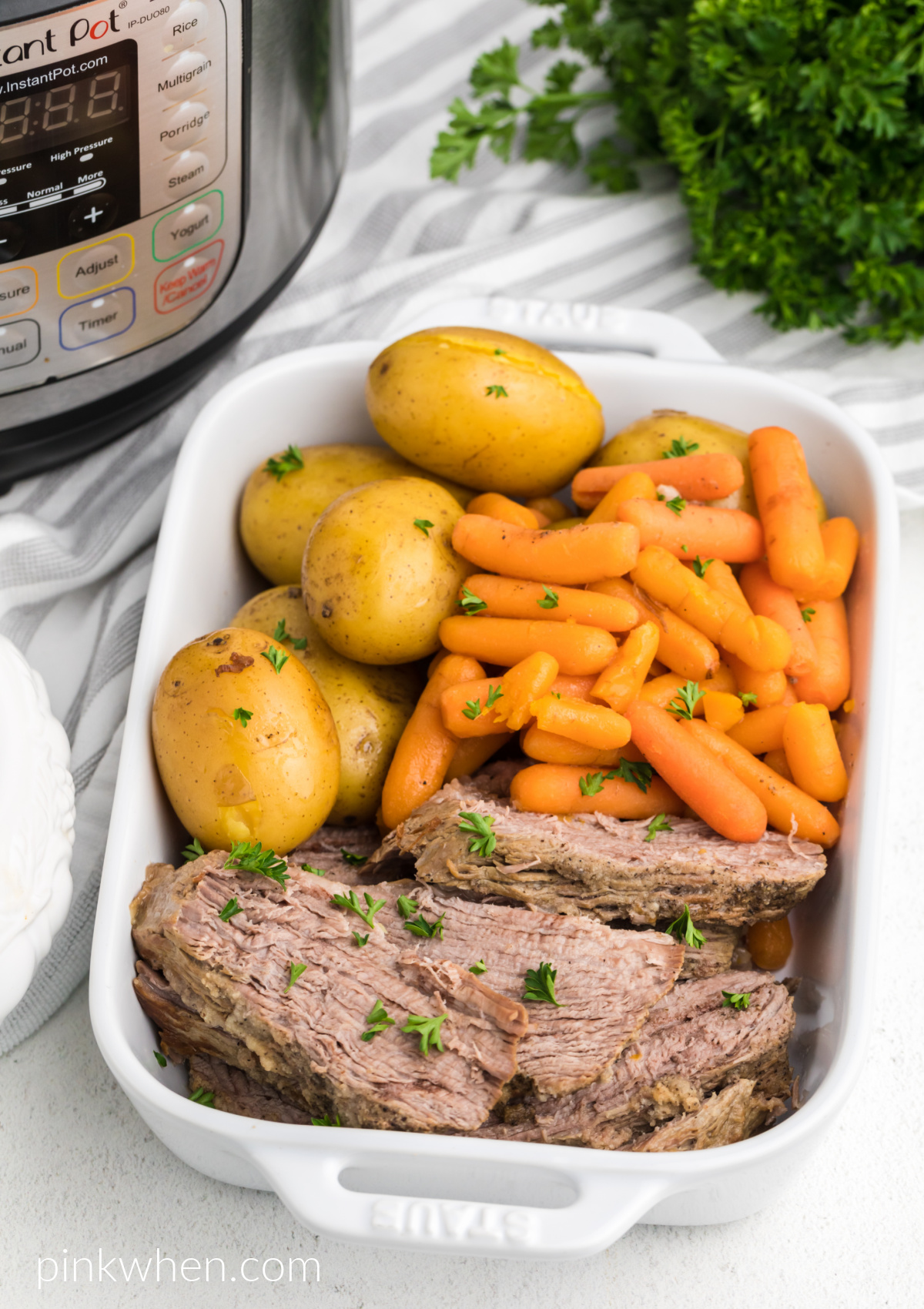 Tri Tip roast made in the instant pot with vegetables and served in a white dish. 