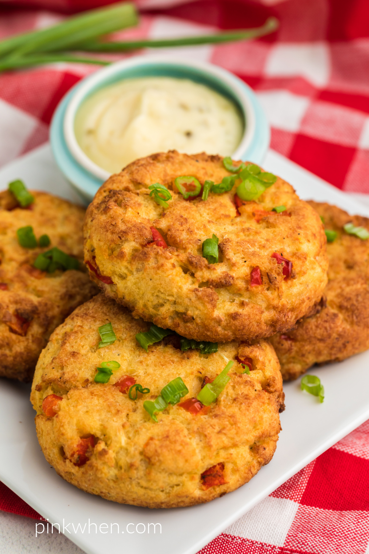 Crab cakes topped with green onion tops ready to eat. 