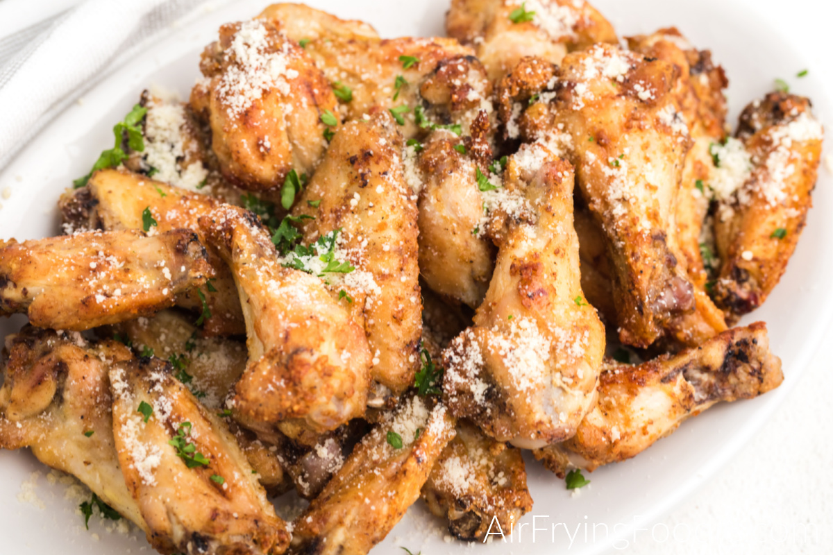 Garlic Parmesan Chicken Wings made in the air fryer on a white serving platter ready to serve. 