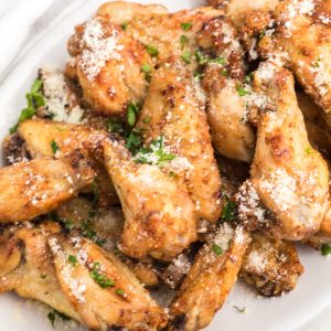 Air Fryer Garlic Parmesan Chicken Wings garnished with fresh parsley and parmesan cheese.