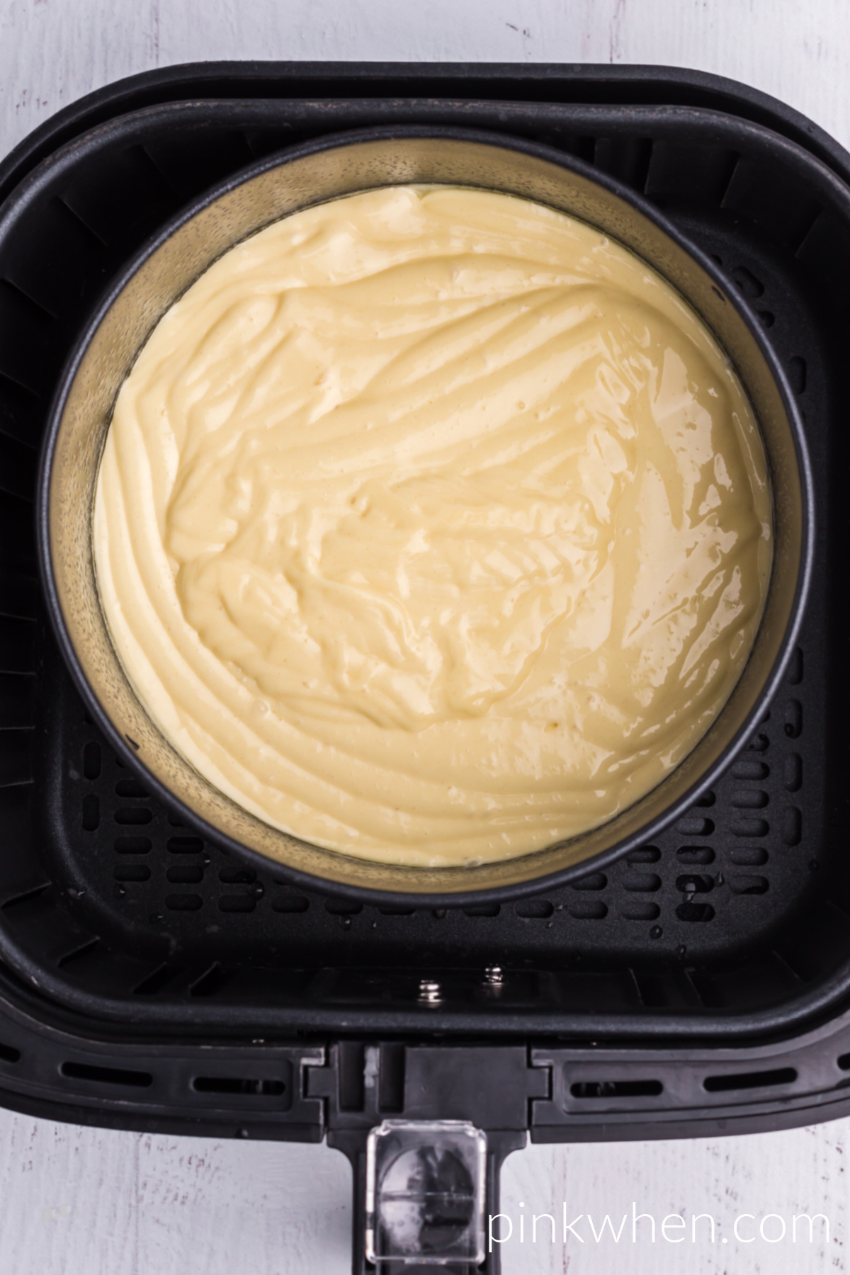 Air Fryer cake pan with batter in the air fryer basket ready to cook.