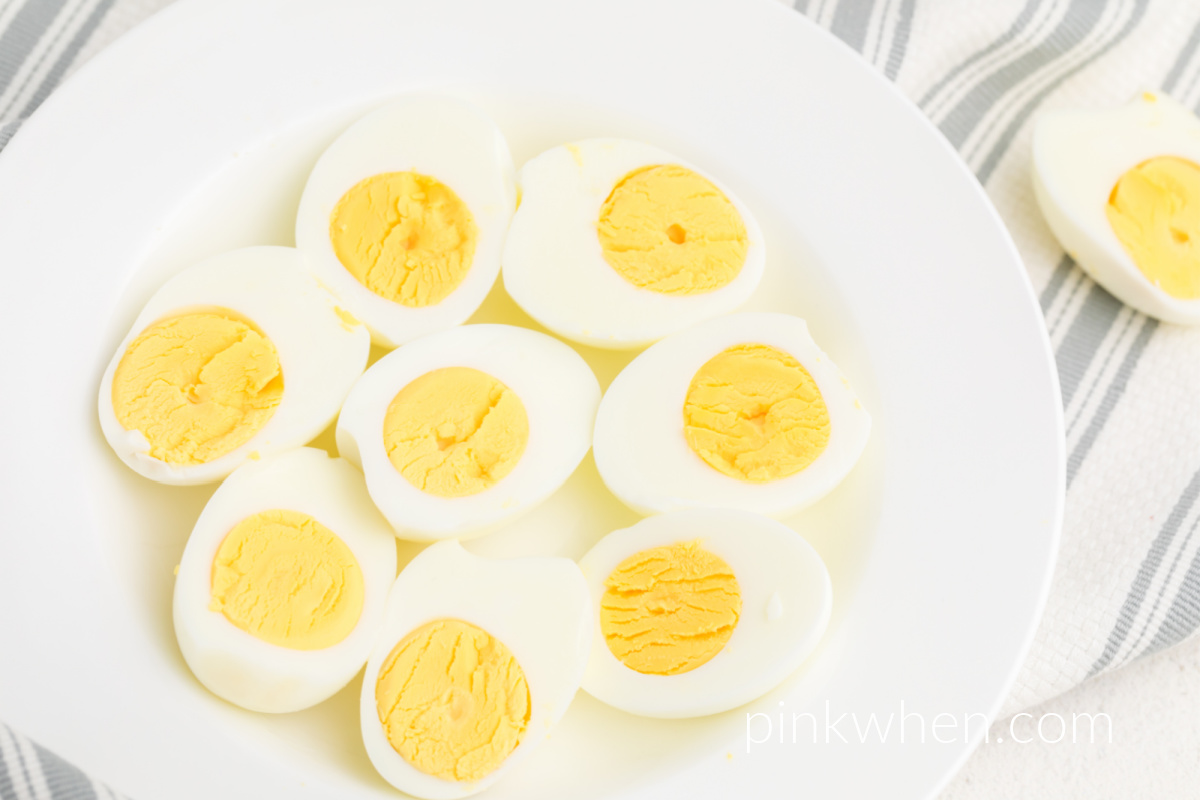 Air Fryer Boiled Eggs that have been cut in half and are served on a white dish. 