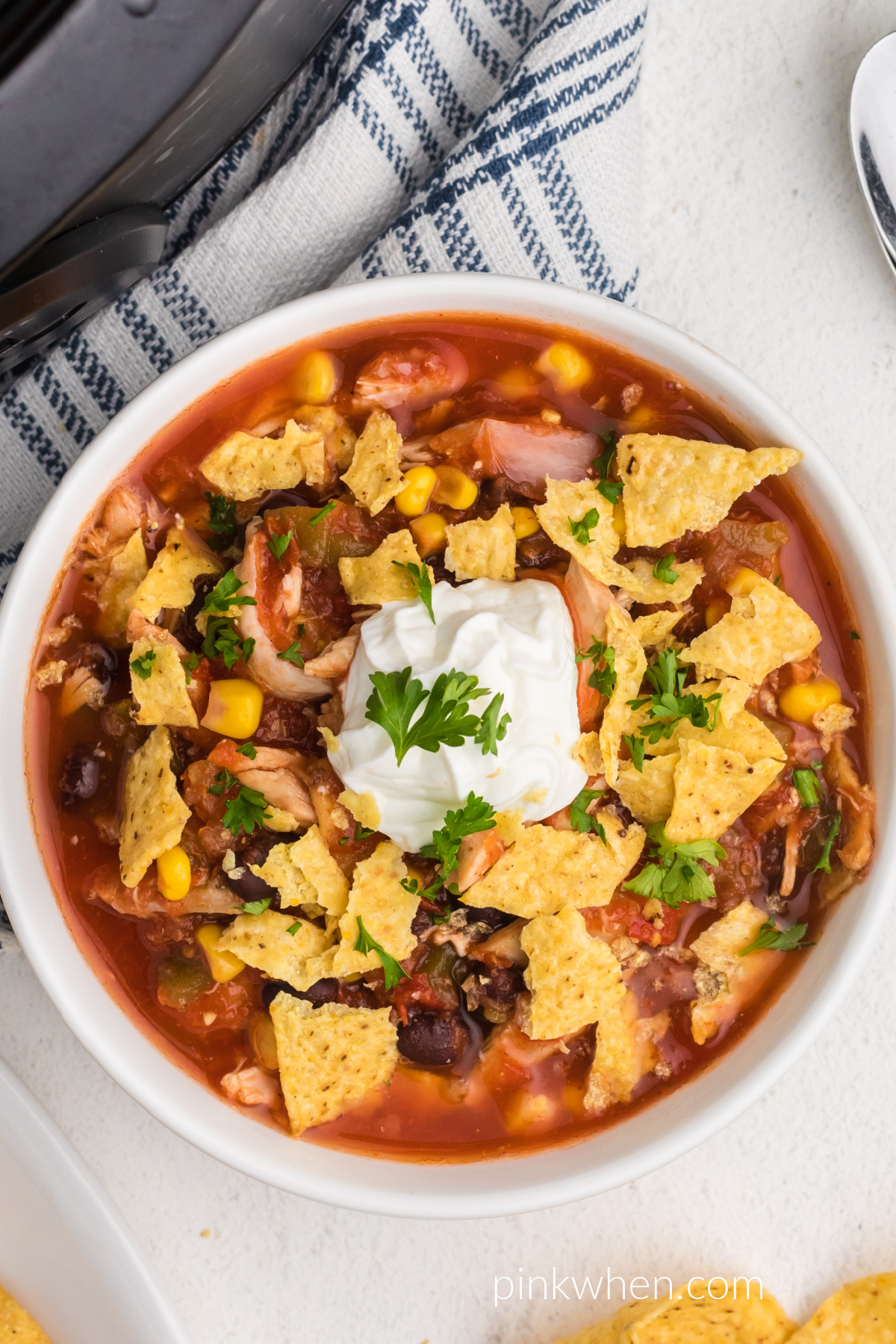 Slow cooker southwestern chicken tortilla soup in a bowl with sour cream and fresh cilantro. 