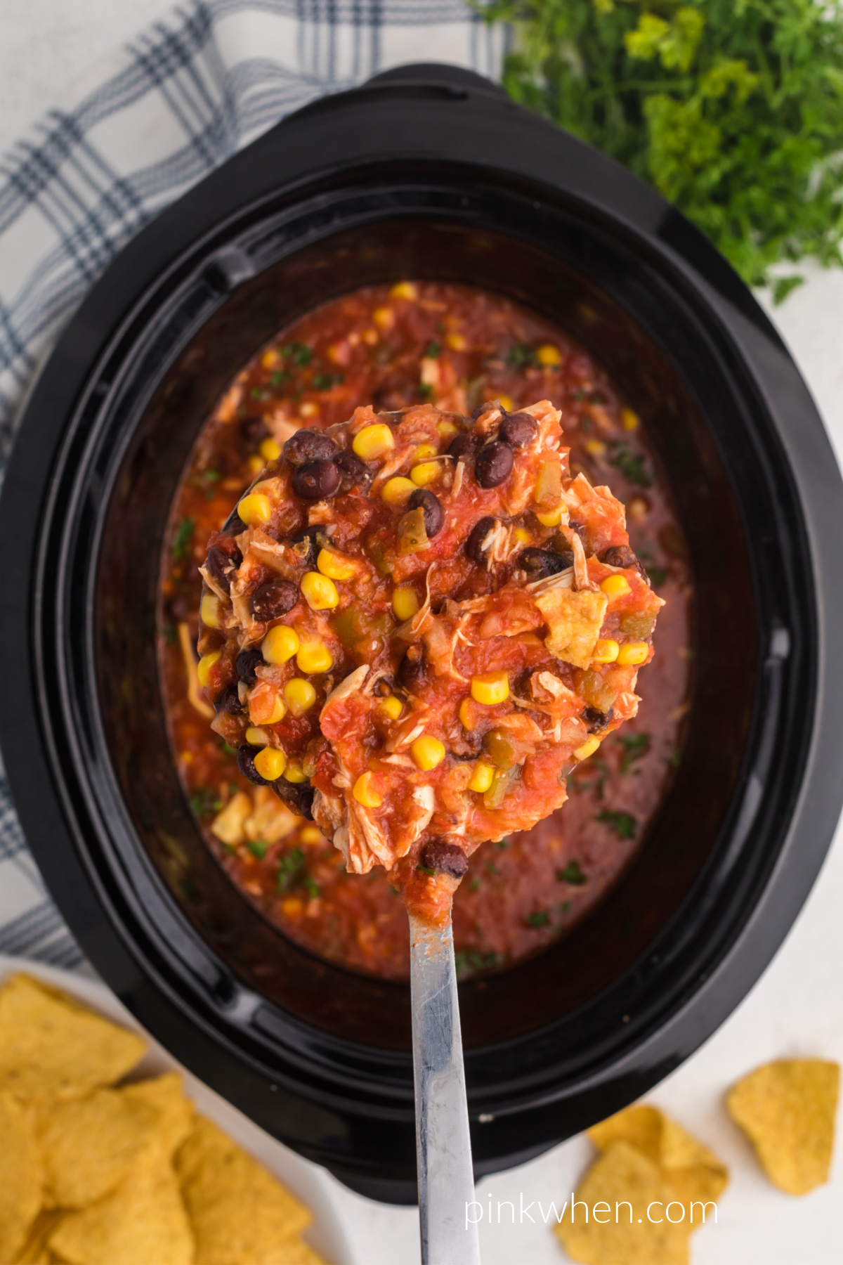 A scoop of chicken tortilla soup from the slow cooker, ready to serve. 