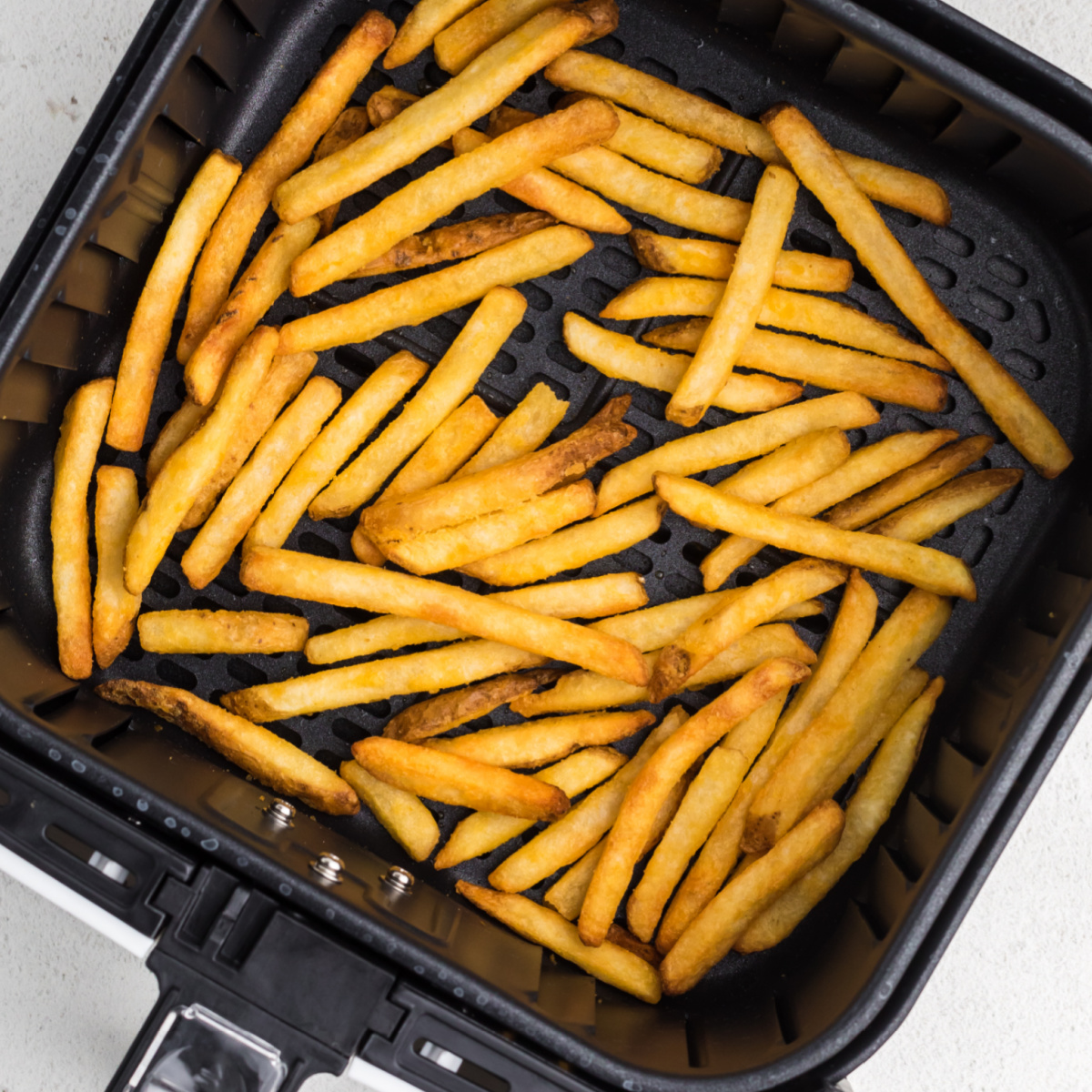Air Fried French fries in the basket of the air fryer.