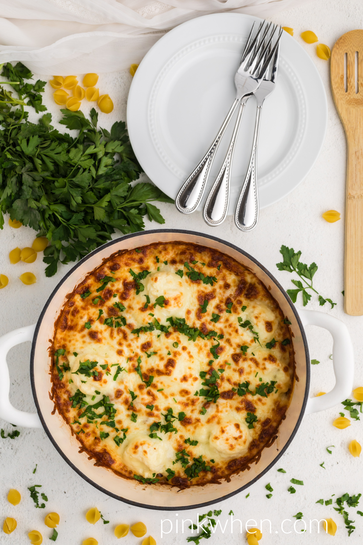 One pot lasagna in a ditch oven with melted cheese and fresh parsley on top. 